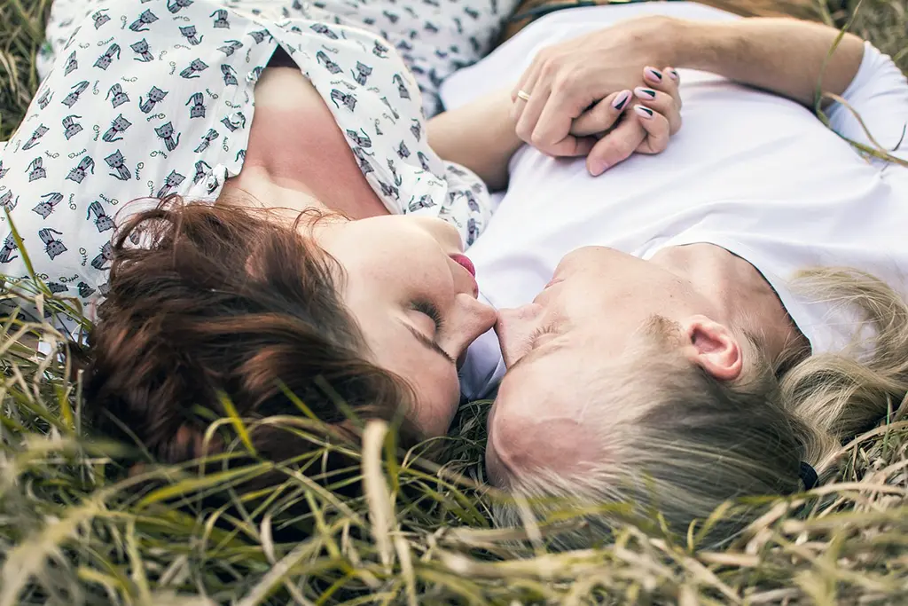 Couple laying peacefully on grass, symbolizing secure and harmonious relationships